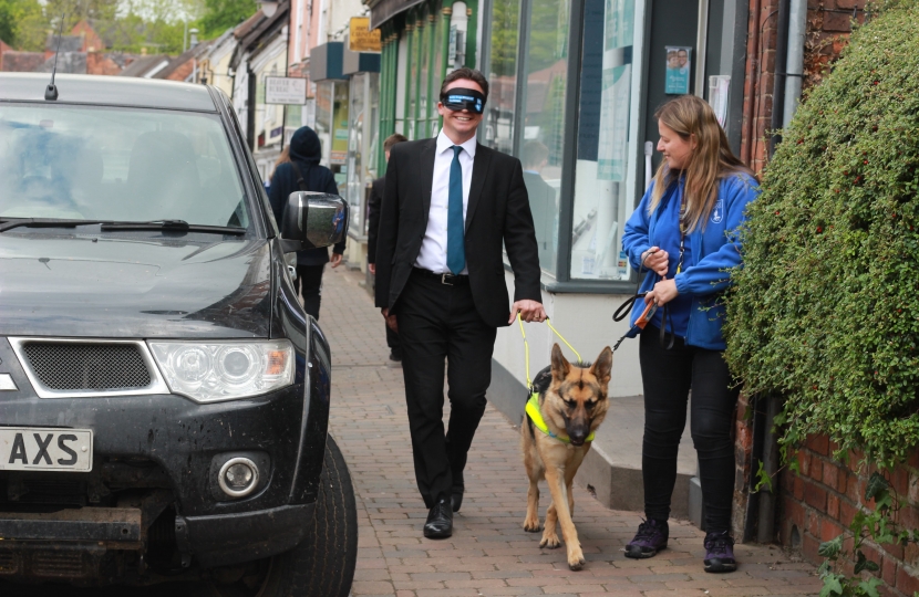 Nigel Huddleston MP walking around car