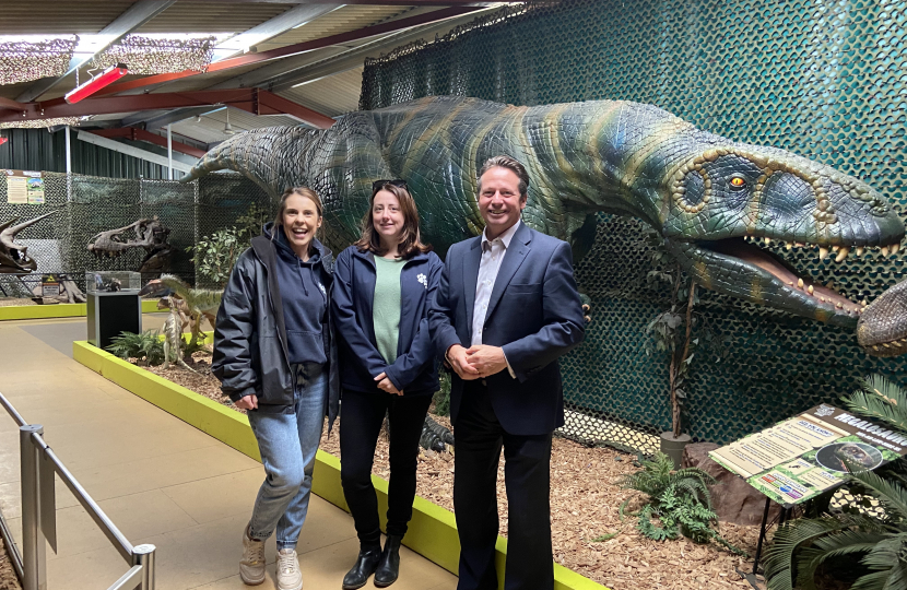 Nigel Huddleston MP alongside a dinosaur and All Things Wild staff.